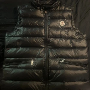 Moncler gui väst - Köpte denna innan sommaren av kille här på Plick så säger att den är äkta,  Den är i bra skick dock kan dragkedjan vara lite jobbig. Storlek 2/M