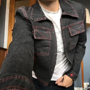 Jeansjacka  - Jättefin jeansjacka/ typ en tröja, den är tunn.  Väldigt bra skick.  Skulle säga storlek 36 Mörkgrå/svart med röda broderade detaljer samt röda sömmar ❤️❤️❤️