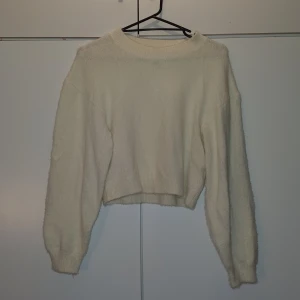 Vit mjuk stickad tröja - En vit stickad lite kortare långärmad tröja. Den är extremt mjuk och passar till alla byxor. Världens bästa vinder/höst tröja. Använd ett par gånger därav lågt pris.