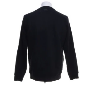 Svart tröja med tryck - Säljer en svart tröja med ett coolt tryck av en figur med solglasögon på framsidan. Tröjan har långa ärmar och är perfekt för en avslappnad stil. Passar bra till både jeans och joggers!