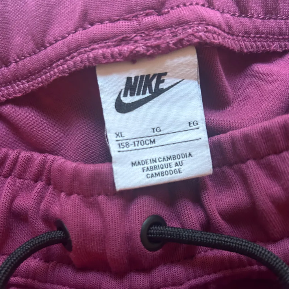 Ett par Nike tech byxor vinröda i utmärkt skick. Använda 2-3 gånger. Nypris 900kr. . Jeans & Byxor.