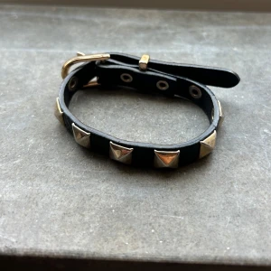 Armband - Säljer mitt valentino liknande armband. Det är några är gammalt men inte använt det. Det är inte min stil men den är i fint skick!!😍 svart med guldiga nitar