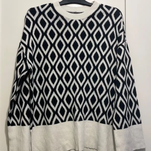 Svartvit mönstrad tröja från Amisu - Säljer en snygg och stilren svartvit tröja från Amisu (Newyorker). Den har ett coolt geometriskt mönster som verkligen sticker ut. Tröjan är långärmad och perfekt för både höst och vinter. Den är i storlek XL och är superbekväm att ha på sig. Perfekt för att hålla sig varm och trendig! pris kan diskuteras 🩷