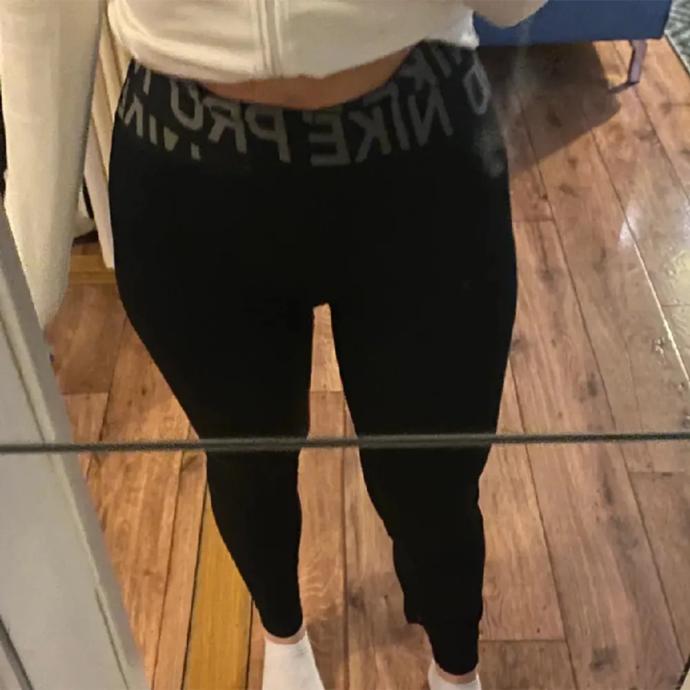 Säljer ett par svarta Nike Pro leggings i storlek M. De är tillverkade i Dri-FIT-material som håller dig torr och bekväm under träning. Högmidjade med en bred resår i midjan för extra stöd. Perfekta för gymmet eller löprundan!. Jeans & Byxor.