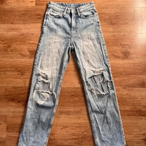 Snygga / coola Ljusblå jeans med slitningar från h&m - Säljer ett par snygga ljusblå jeans i loose fit och straight model. De är högmidjade och har coola slitningar på knäna för en avslappnad look. Perfekta för en casual outfit! 