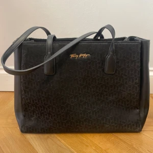 Tommy Hilfiger väska  - Snygg, svart handväska från Tommy Hilfiger. Använd ett par gånger men i mycket gott skick. 2 små innefack och ett stort fack i mitten <3