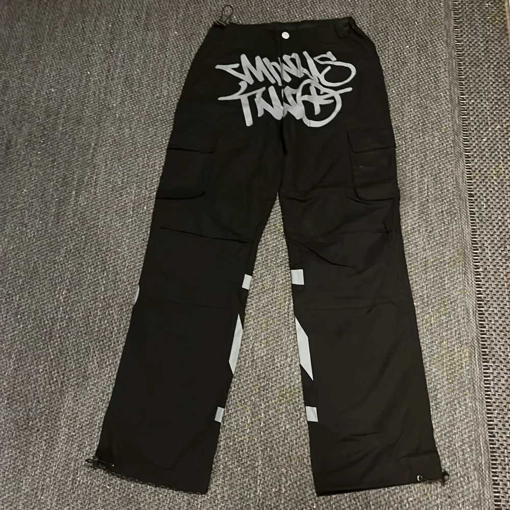 Säljer ett par svarta cargopants. Byxorna har flera fickor och en loose passform, perfekt för en avslappnad stil. De är i bra skick och redo för nya äventyr!. Jeans & Byxor.