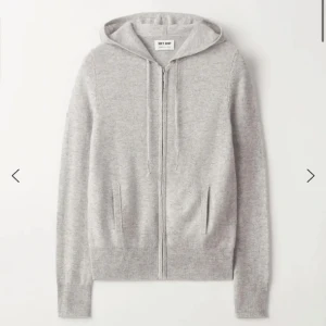 Grå hoodie från Soft Goat - Mysig och stilren grå hoodie från Soft Goat i kashmir. Perfekt för kyliga dagar med dragkedja och fickor framtill. Den har en normal passform och är superbekväm att ha på sig. Perfekt för både vardag och avslappnade tillfällen.