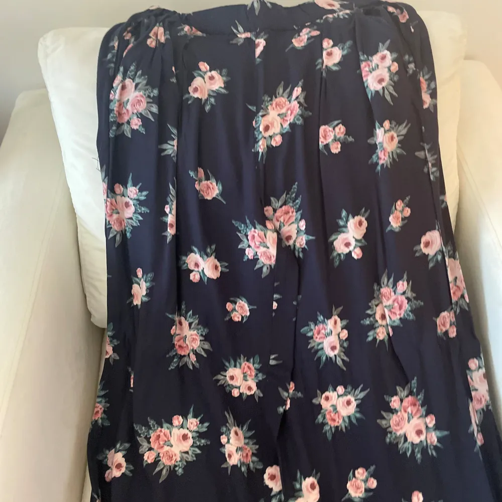 Säljer en superfin byxa med blommigt mönster. Byxan är mörkblå med rosa och vita blommor, perfekt för både vardag och fest. Den har en bekväm passform och är gjord i ett mjukt material som faller snyggt. Passar perfekt till sommaren eller våren! 🌸. Farkut & Housut.