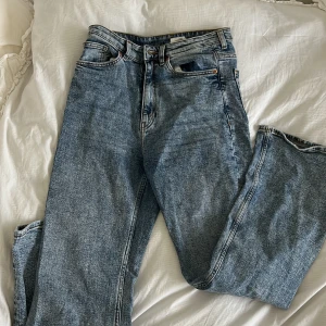 Blå jeans från MONKI - Säljer ett par högmidjade blå jeans från MONKI med fem fickor och knappgylf. Man får sjukt fin rumpa i dem, användt ett par gånger men inga fel på dem! (Passar 38 eller 40)
