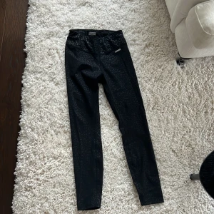 Svarta leopardmönstrade leggings från Stronger - Säljer ett par svarta leggings från Stronger med leopardmönster i storlek S. De är i nyskick och perfekta för träning.