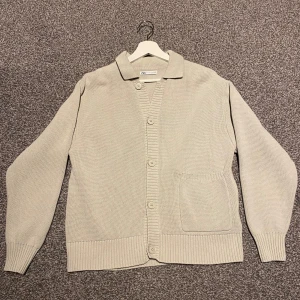 Beige stickad kofta från Zara - Säljer en stilren beige stickad kofta från Zara. Koftan har långa ärmar, knappar framtill och en praktisk ficka på sidan. 