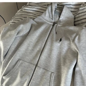 Grå zip hoodie från Ralph Lauren - Säljer en riktigt snygg hoodie från ralph lauren som är i nyskick. Nypris ligger på 2200kr.