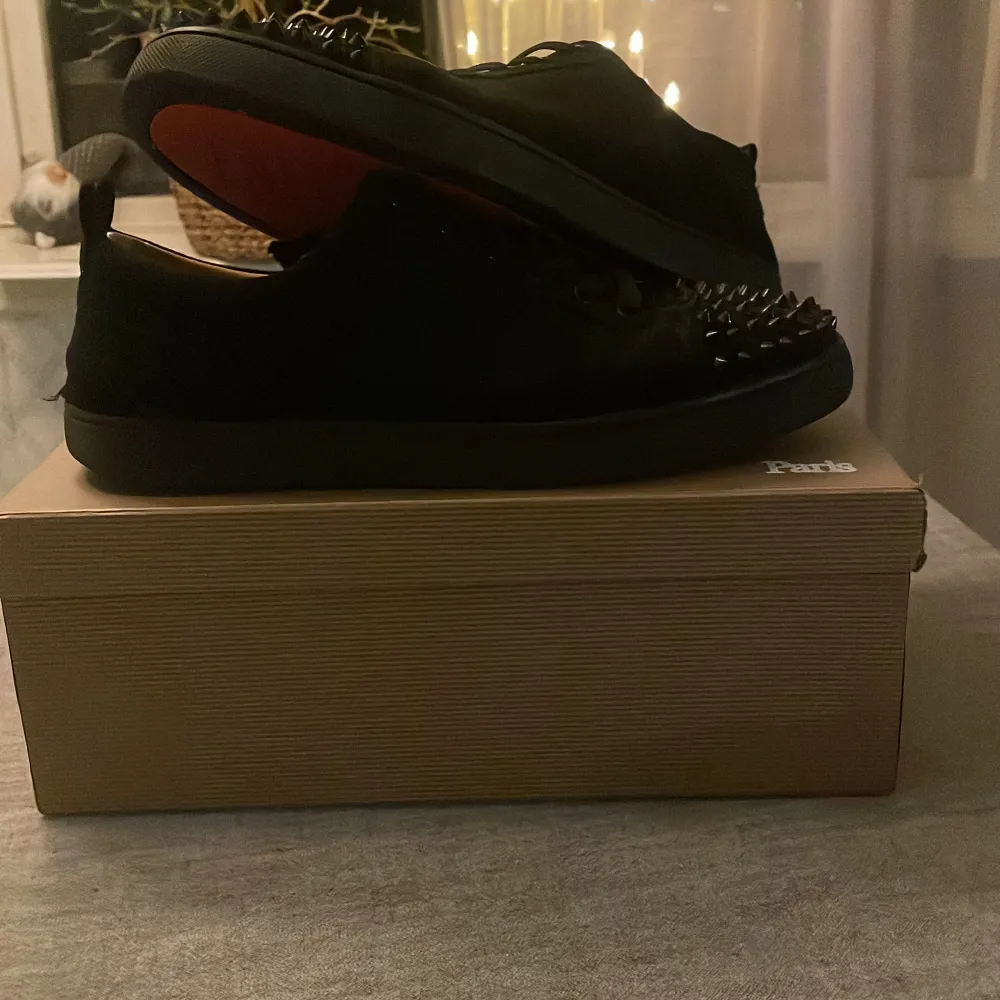 Säljer ett par svarta sneakers från Christian Louboutin i nytt skick. Skorna har coola nitar på tån och den klassiska röda sulan. Perfekta för att ge din outfit en edgy touch. Kommer med originalkartong och kvitto.. Skor.