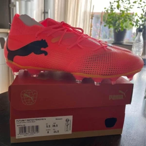 Puma Future Z Match FG/AG - Säljer ett par HELT NYA Puma Future Z Match FG/AG fotbollsskor i damstorlek 38.5. Skorna har en snygg svart Puma-logga på sidan och är designade för spel på både gräs och konstgräs. De har en tight passform med snörning för optimal kontroll och komfort på planen.