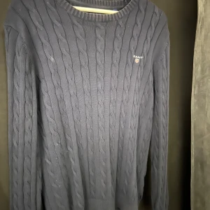 Mörkblå kabelstickad tröja från GANT - Säljer en snygg mörkblå kabelstickad tröja från GANT i medium