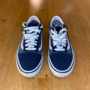 Blå/ vita sneakers från Vans - Snygga blå och vita Vans sneakers med klassisk design och snörning. Perfekta för skateboarding eller vardagsbruk. Gummisula med bra grepp och bekväm passform. Mycket bra skick.