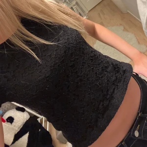 Svart spetsblus - Säljer en snygg svart spetsblus i mycket bra skick. Den är kortärmad och har en tight passform som framhäver figuren. Perfekt för både fest och vardag! 🖤passar xxs - s