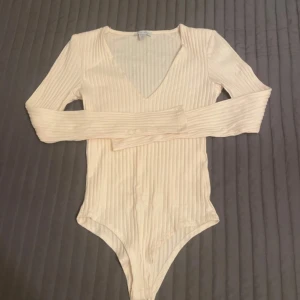 Vit bodysuit från New Yorker - Vit  bodysuit från New Yorker med v-ringning och långa ärmar 🤍