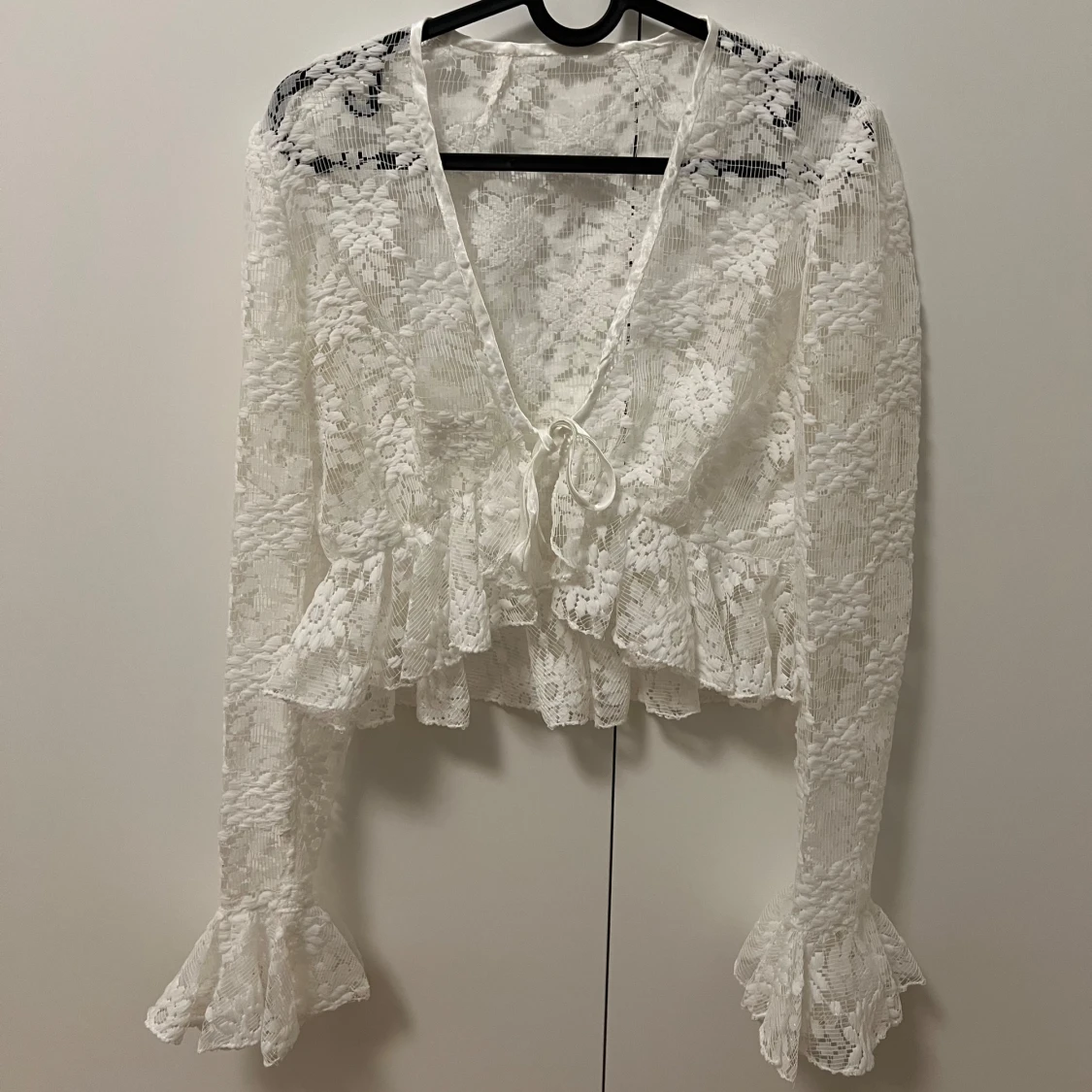 Vit spetsblus med volangdetaljer