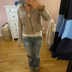 Beige skinnjacka med dragkedja - Säljer en snygg beige skinnjacka i bra skick. Jackan har en cool dragkedja framtill och långa ärmar med snygga detaljer. Perfekt för höst och vår, och funkar både till vardags och fest. Jag är 168cm lång och skulle säga att den känns som en xs-s 