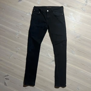 Nudie jeans Svarta  - svarta jeansbyxor från Nudie Jeans med en klassisk femficksdesign. De har en slim passform och är tillverkade i ett stretchigt material för extra komfort. Storlek W 30 L32. Model Skinny Lin. Nypris 1400kr.