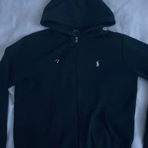 Svart hoodie Ralph Lauren - Äkta Svart Ralph lauren zip, skick 7/10. Lite uträttad 