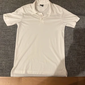 Vit kortärmad pikétröja från Oakley - Säljer en stilren vit pikétröja från Oakley i storlek M. Tröjan är kortärmad och har en klassisk krage med knappar. Perfekt för både vardag och sportiga aktiviteter. Materialet känns lätt och bekvämt. Passar bra till sommarens alla äventyr! 🌞 Pris går alltid att förhandlas! 
