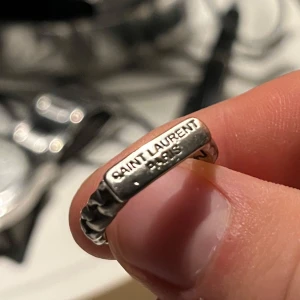 SAINT LAURENT RING - Tjena! Säljer nu denna SAINT LAURENT ring! | Skick 7/10 bra | lite missfärgning på sidan! Syns knappt vid användning! | Nypris ca 3000kr | Mitt pris 799kr (diskuterbart!) | Kom pm för fler bilder eller vid funderingar! Postas eller möts upp i Gävle!