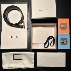 Gucci bälte - Säljer ett snyggt Gucci bälte i mycket bra skick. Det har det klassiska Gucci-monogrammet i beige och brunt, med ett stilrent silverfärgat spänne. Perfekt för att ge din outfit en lyxig touch. Kommer med originalförpackning och påse.  Nypris ligger på 5800kr och jag säljer mitt för 2499kr! Storlek 85. Bältet är Reversible så man kan välja mellan svart eller Gucci mönstret. 