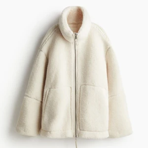 Vit teddyjacka med dragkedja - Säljer nu min populära vita/beige teddyjacka med dragkedja och stora fickor framtill. Perfekt för kalla dagar med sin fluffiga och varma design. Jackan har en avslappnad passform och långa ärmar. Strl S. Endast testad. 