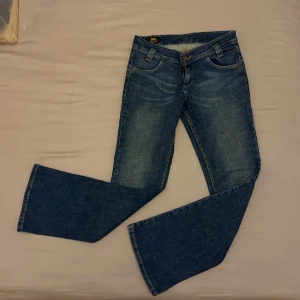 Blå jeans från Lee - Snygga blå jeans från Lee med bootcut-stil. Klassisk femficksdesign och bekväm passform. Perfekta för en avslappnad look.