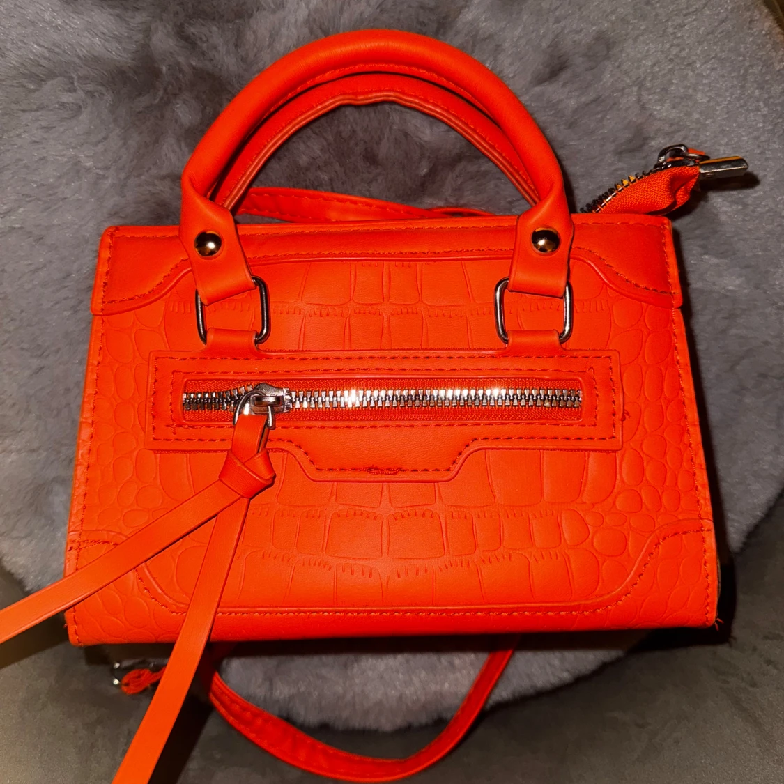 Orange handväska med krokodilmönster