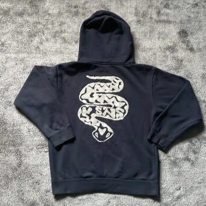 Svart hoodie med ormtryck från SNS - Snygg svart hoodie från SNS med ett coolt ormtryck i silver på ryggen och SNS-logga på bröstet. Perfekt för vintern, XS men passar som S