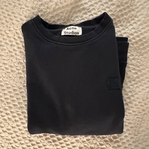 Svart tröja från Acne Studios - Säljer en stilren svart tröja från Acne Studios. Tröjan har en klassisk design med rund hals och långa ärmar. Perfekt för en minimalistisk look.