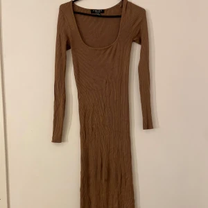 Brun ribbad klänning från New yorker - Snygg brun ribbad maxi klänning från new torker med lång ärm och rundad hals. Perfekt längd för mig som är 164cm.  Använd ett par gånger. 