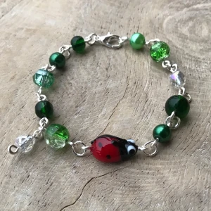Armband  - Vackert silver armband av gröna glaspärlor och en nyckelpiga. 🐞🌿🍄