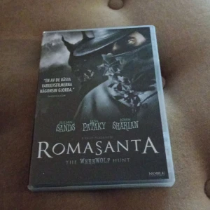 Romasanta: The Werewolf Hunt - DVD-film med titeln 'Romasanta: The Werewolf Hunt'. Omslaget visar en mystisk figur i mörka toner med texten 'En av de bästa varulvsfilmerna någonsin gjorda'. Skådespelare inkluderar Julian Sands, Elsa Pataky och John Sharian. Filmen är utgiven av Noble.