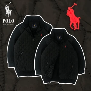 Svart quiltad jacka från Ralph Lauren - Säljer en stilren svart quiltad jacka från Ralph Lauren med dragkedja och broderad logga i rött på bröstet. Jackan har långa ärmar och två praktiska fickor med dragkedja framtill. Perfekt för en cool och avslappnad look. Chest 40cm. Sleeve 46cm. Length 60cm