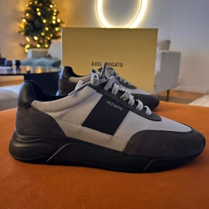Arigato  Genesis Vintage Runner Sneaker - Hej, Säljer nu ett par helt nya grå sneakers från Axel Arigato med svarta detaljer och snörning. Skorna har en modern design med en kombination av mocka och syntetmaterial.   Helt oanvända och i låda.    Size: EU 42 Modell: Genesis Vintage Runner Sneaker Black/Grey Nypris/New price 2.600kr / 260 euro!  