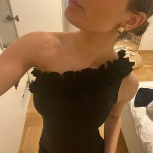 Svart offshoulder body - Svart offshoulder body med volangdetaljer längs överkanten. Perfekt för nyår🎉