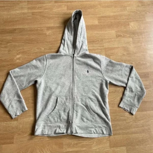 Grå Polo Ralph Lauren zip up - Tjena säljer en grå polo hoodie storlek XL i barnstorlek då passar som en S