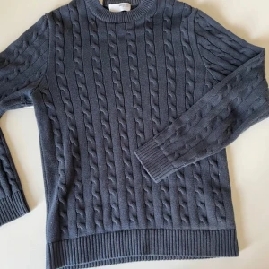 Blå kabel stickad tröja  - Väldigt fin stickad tröja i färgen blå, den är från Selected Homme.                                                      Storlek: S.                                                                                    Nypris: 699                                                                       Den är sparsamt använd och i bra skick. Skriv gärna vid frågor.