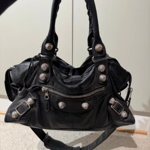 Balenciaga väska  - Favvoväskan letar nytt hem! Säljer min älskade balenciaga då den inte kommer till användning längre. I utmärkt vintage skick. Har inget kvitto då den köptes begagnad, men det finns flera detaljer på väskan som intygar äkthet! (skickar gärna fler bilder om man är intresserad). Kommer med allt som visas på bilden! Hör gärna av er vid frågor och funderingar! 🤗🙌🏼🩷