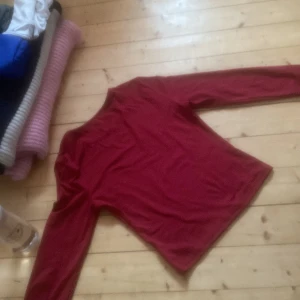 Röd långärmad tröja - Säljer en enkel och stilren röd långärmad tröja. Perfekt för kyligare dagar och lätt att matcha med olika outfits. Tröjan har en rund halsringning och är i ett mjukt material.