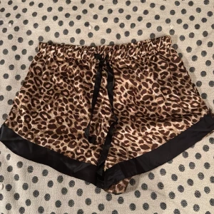 Leopardmönstrade pyjamasshorts från Bubbleroom - Snygga leopardmönstrade pyjamasshorts från Bubbleroom med svarta detaljer. De har en elastisk midja med knytband för justerbar passform🐆