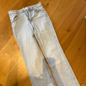 Ljusblå jeans från Mango Denim - Snygga ljusblå jeans från MNG Denim i en klassisk straight fit. De har en hög midja och är tillverkade i ett bekvämt denimtyg. Perfekta för en avslappnad stil med femficksdesign och knappgylf.