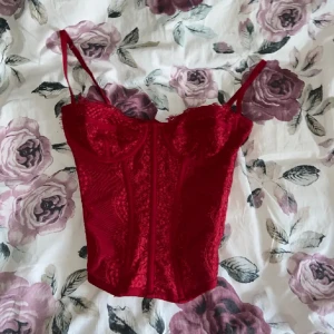 Röd korsett topp - As snygg röd korsett topp. Använd en gång bara och säljer för den inte kommer till användning tyvärr. Kan skicka bild privat på hur den sitter på💋
