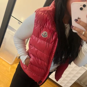 Moncler väst - Säljer nu min fina röda väst från Moncler. Den är äkta och har kvar allt som kom med när den beställdes. Barnstorlek 14Y men passar mig bra som är 165🩷