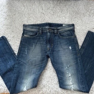 Blå jeans från Diesel - Säljer ett par snygga blå jeans från Diesel, Thavar model. De passar dig som vill ha ett par snygga och cleana jeans med stil. Storlek 31/32. Skriv om frågor!!